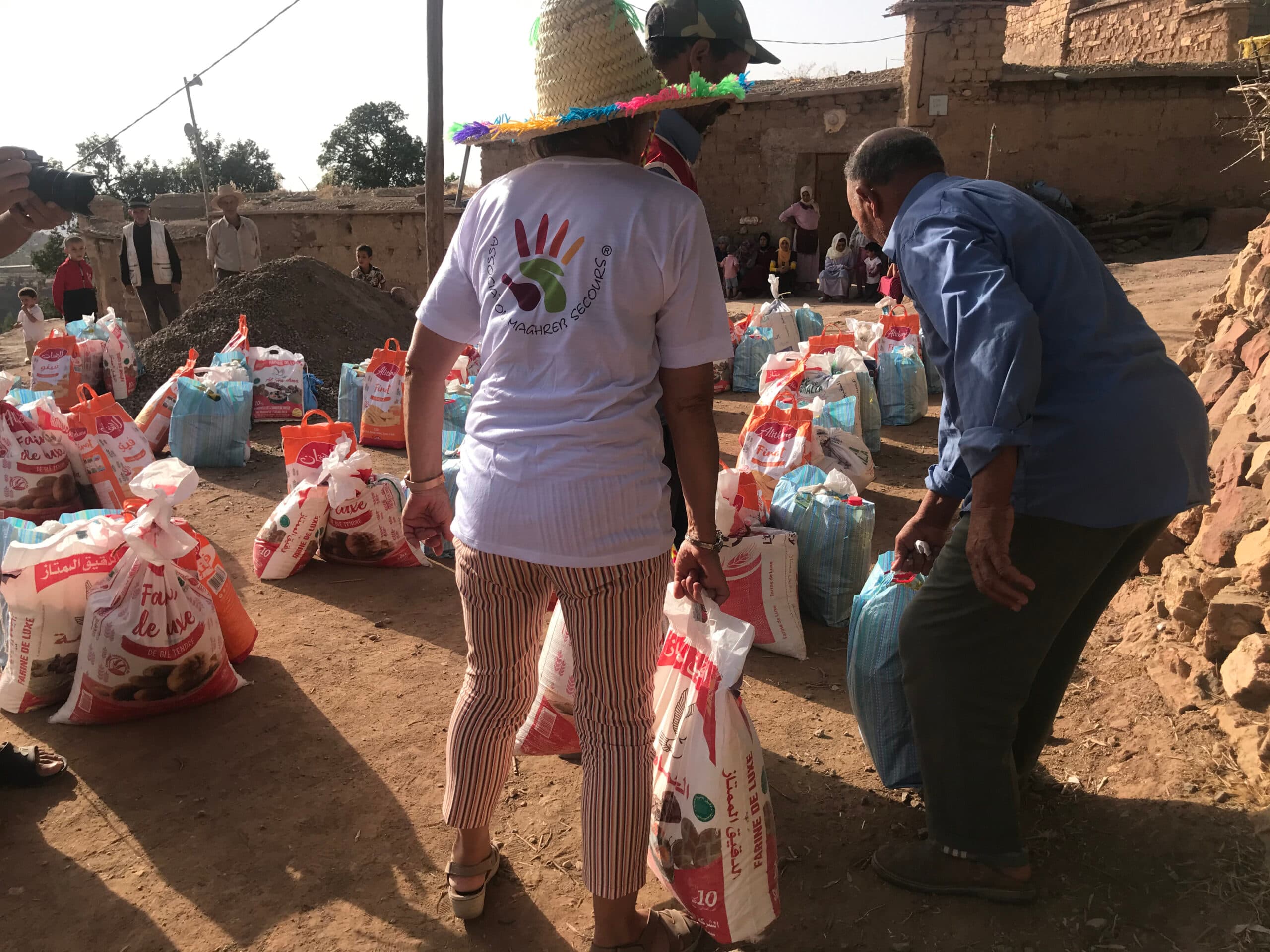 Des bénévoles de Maghreb Secours distribuent des paniers alimentaires dans un village